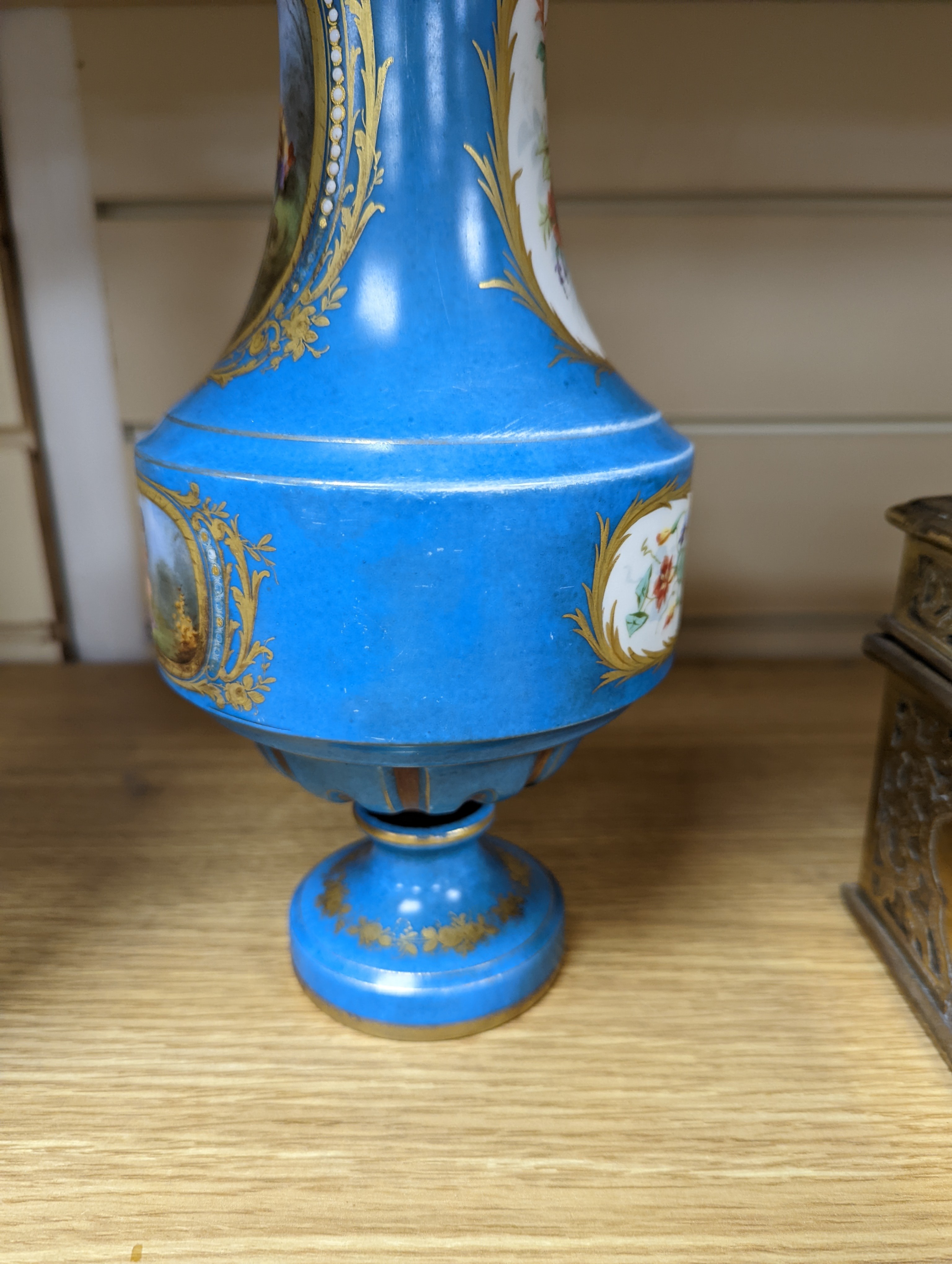 A pair of Sevres style porcelain bleu celeste ground vases and covers, 34cm